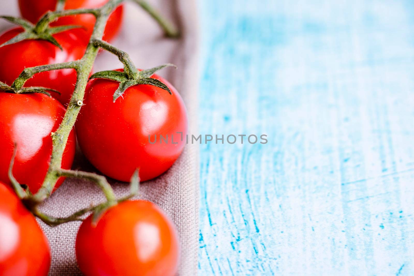 Cherry tomatoes on blue brushstroke background