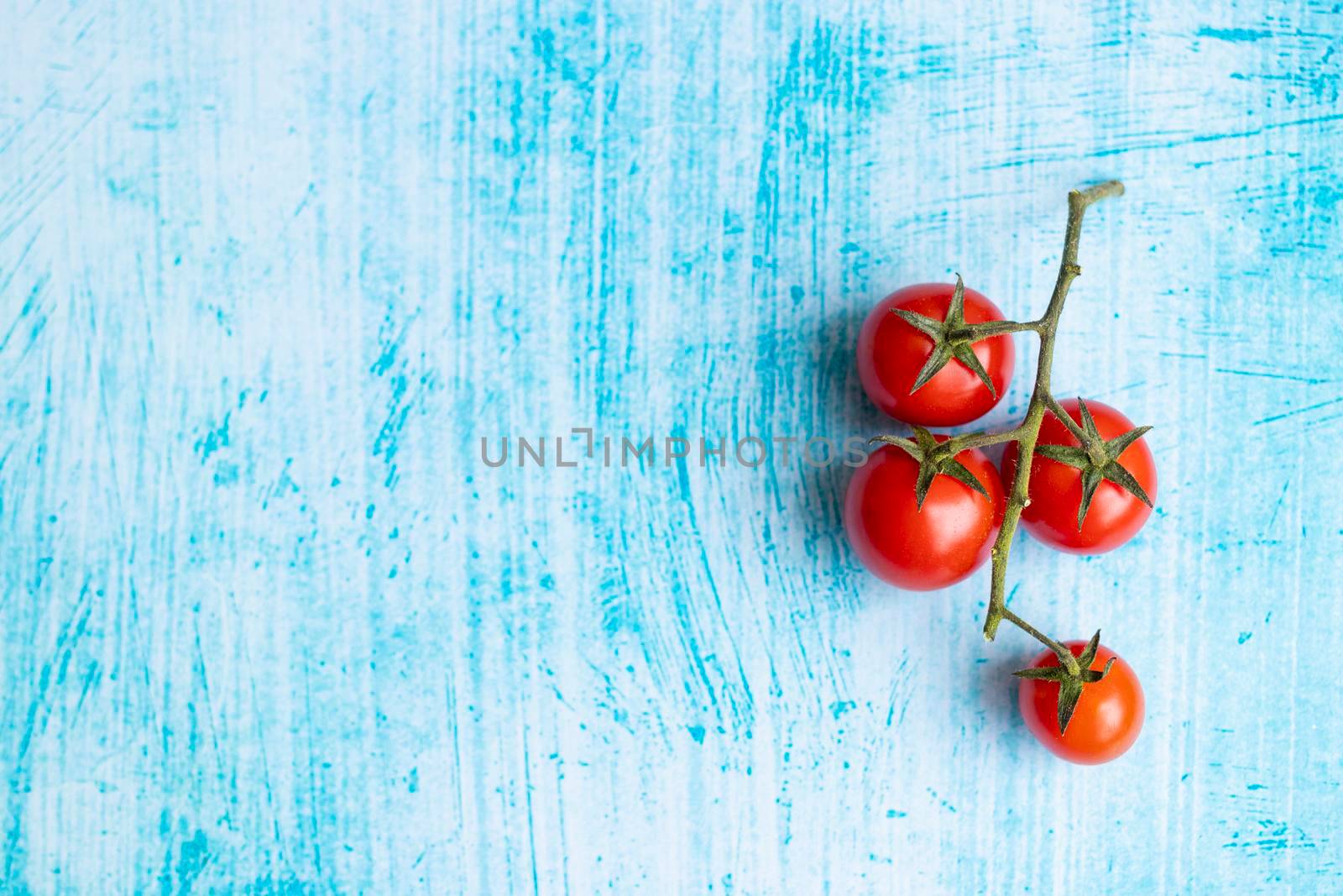 Cherry tomatoes on blue brushstroke background by eagg13