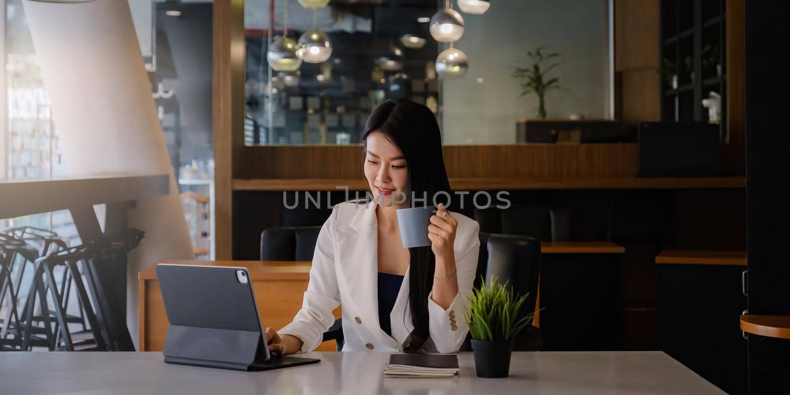 Portrait of an executive business woman advisor, agent, representative with cup of coffee and video call via digital tablet. Smart, intelligent, friendly, concept. by itchaznong