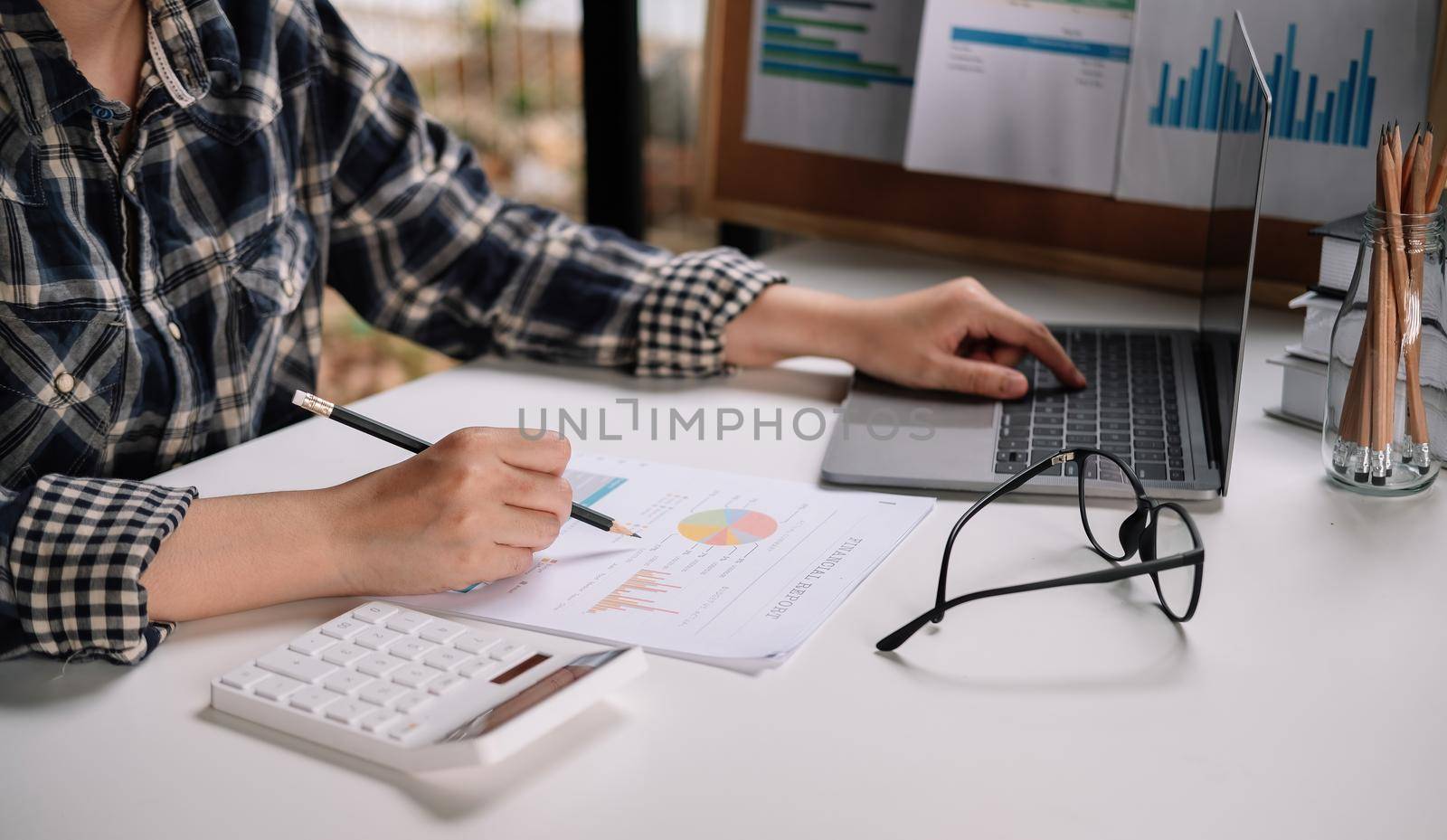 Consult financial concept. Business man pointing at papwework and using laptop computer.