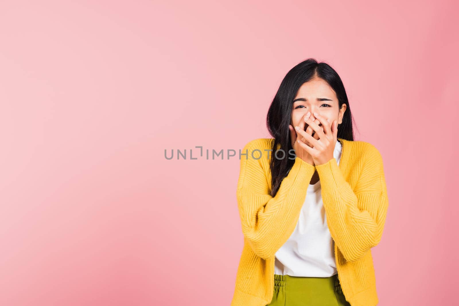 Asian portrait beautiful cute young woman standing amazed, shocked afraid mouth covered gesturing hand palms looking camera, studio shot isolated on pink background, Thai female scared with copy space