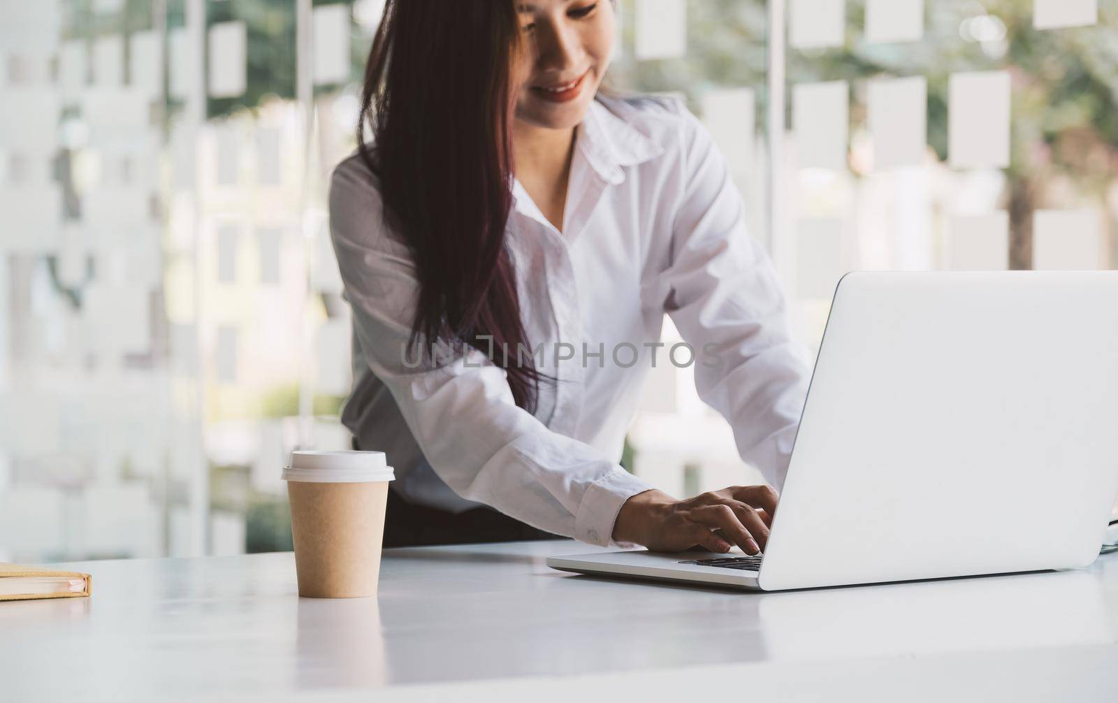 Close up woman using laptop computer on workplace.