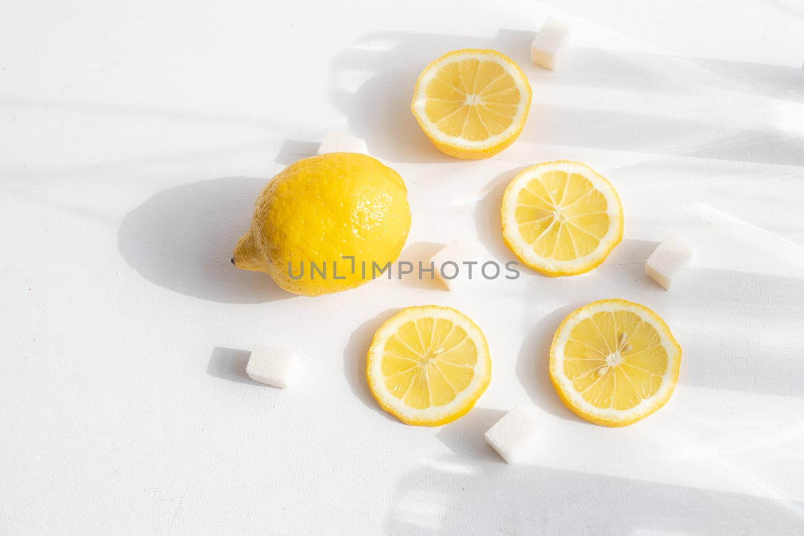 Sliced lemon on a white background . Lemon layout. Sliced fruit. Yellow color. White background. Light and shadow. Citrus. Healthy food. Copy space