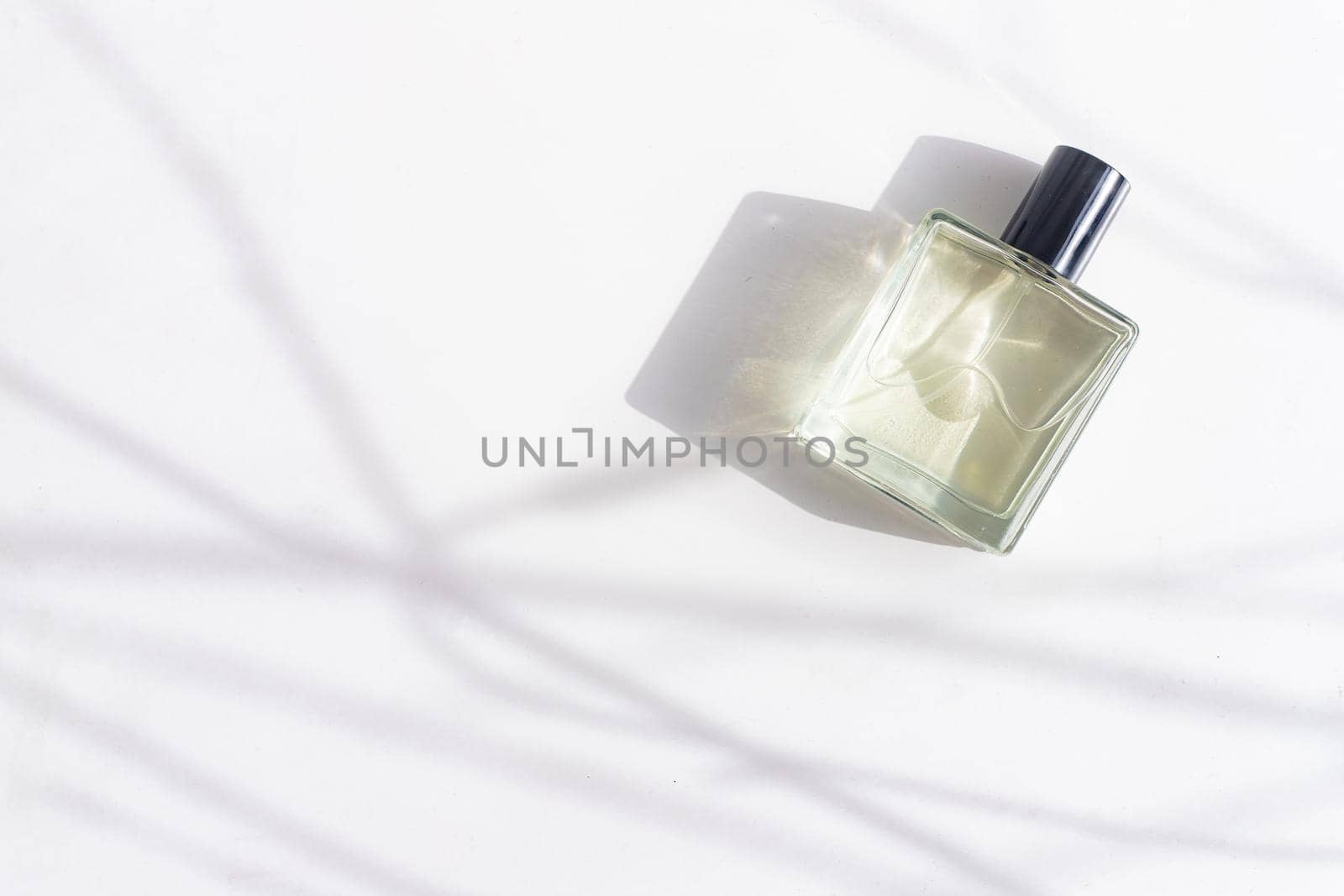 Perfume on a white background with shadows . The choice of perfume. Aromatherapy. Smell. A bottle of perfume. White background. Light and shadows . Copy space