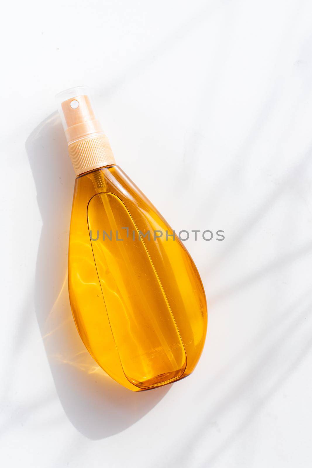 Suntan oil on a white background .Shadows and light. Protect your skin from the sun. A proper and even tan. Copy space