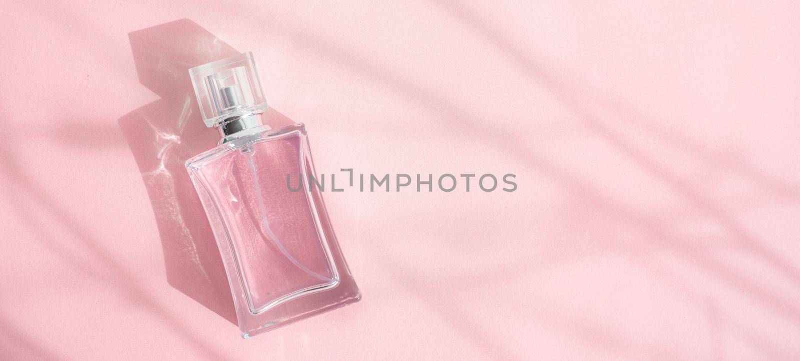 A bottle of perfume on a pink background . Pink perfume. Smell. Aromatherapy. An article with a place for the text about the choice of perfume fragrance. Light and shadows. Naturalness . Copy space