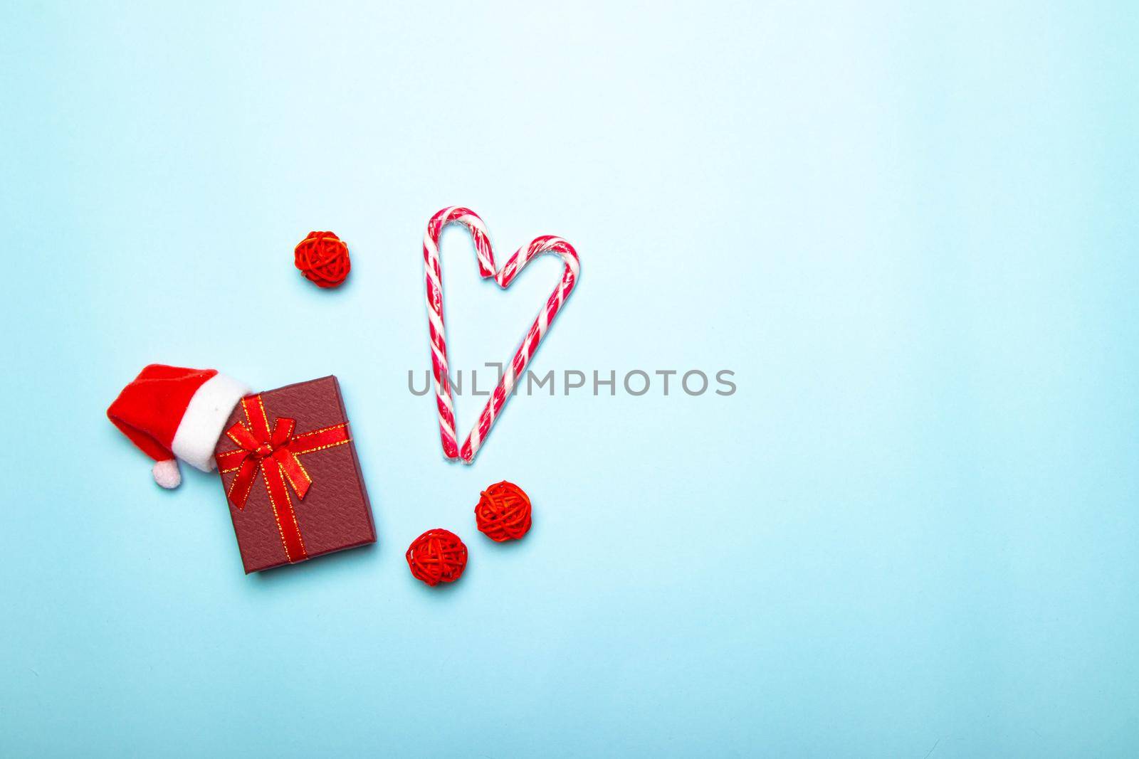 Christmas red gift on a blue background. Gift and candy. Christmas layout. Holiday. New Year. Gifts. Article about choosing gifts. Copy space