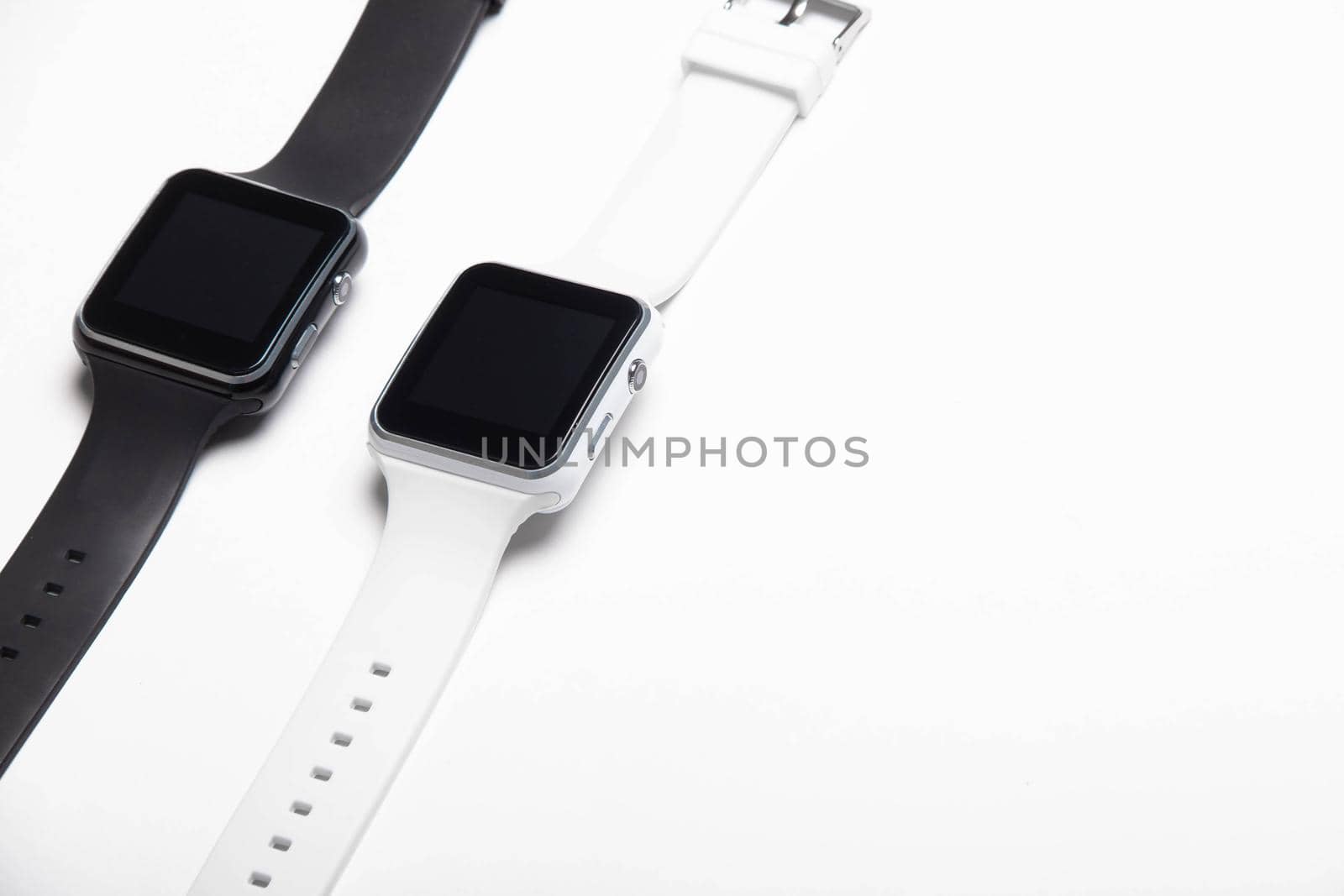 Electronic wrist watch on a white background . White and black wrist watches. Women's and men's watches. Isolated background. Article about modern watches. Article about choosing a watch. Copy space