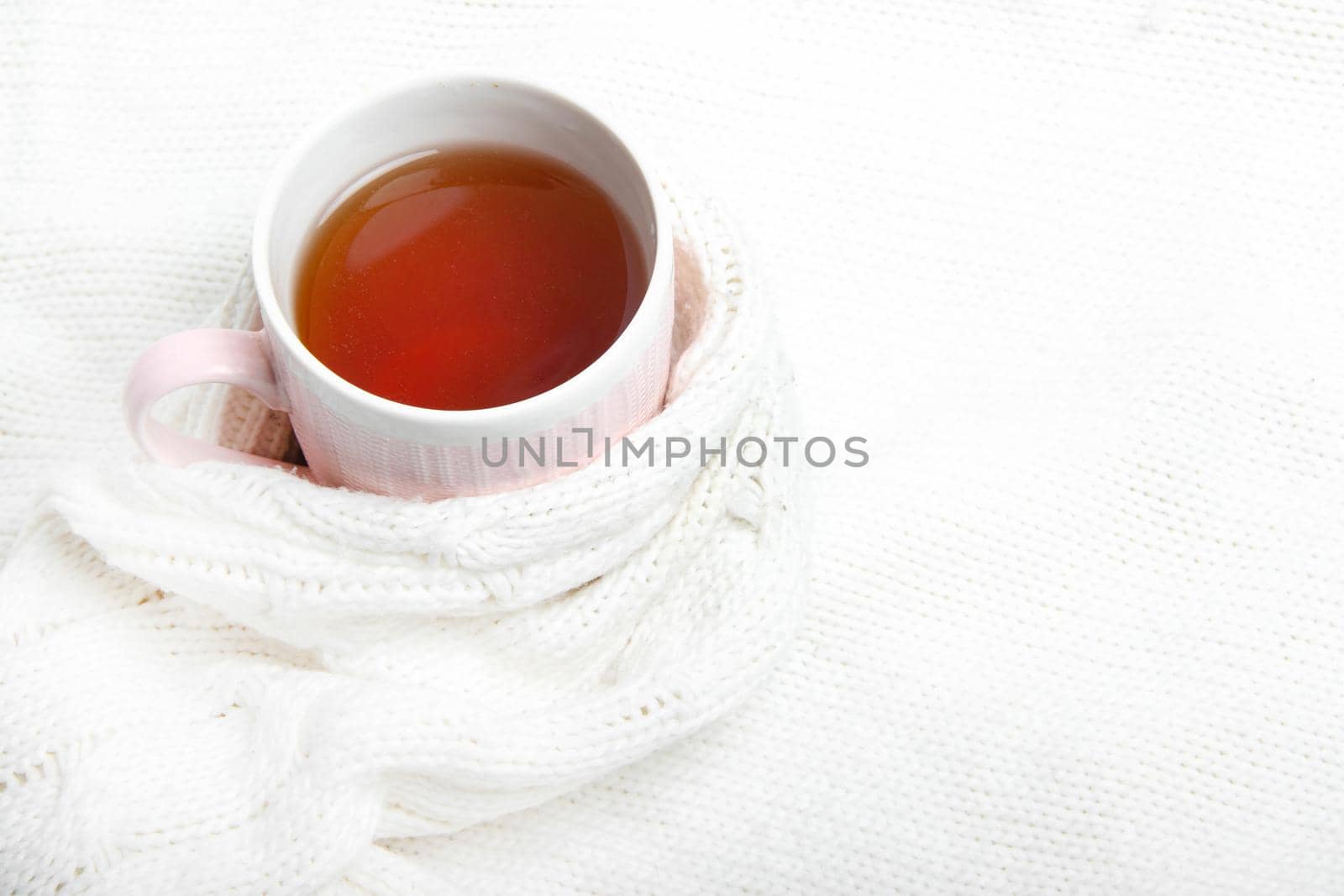A Cup of tea in a knitted sweater . Hot tea. Autumn. Autumn mood. A knitted item. Tea in a Cup. Cold season. Copy space