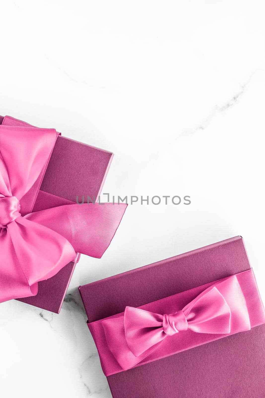 Pink gift box with silk bow on marble background, girl baby shower present and glamour fashion gift for luxury beauty brand, holiday flatlay art design by Anneleven