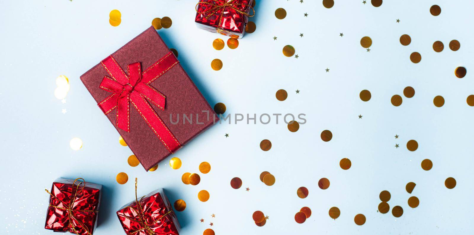 Red confetti gift . Red gift layout on top. Confetti is scattered. New year and Christmas. Valentine's day. Holiday. Article about gifts