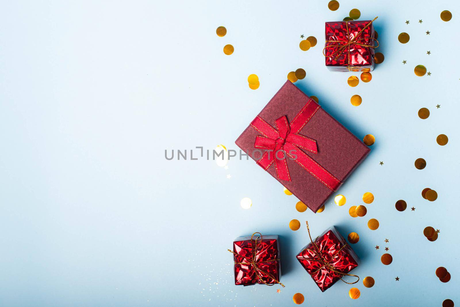 Red confetti gift . Red gift layout on top. Confetti is scattered. New year and Christmas. Valentine's day. Holiday. Article about gifts . Copy space