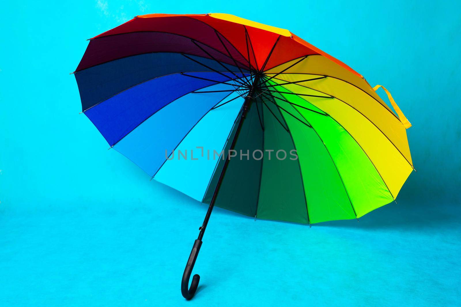 Colored umbrella on a blue background . Bright umbrella. Copy space. Article about the protection from the rain.