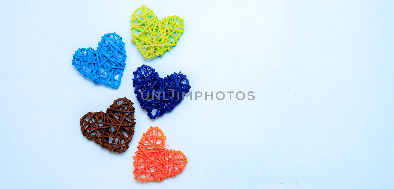 Colored hearts on a blue background . Hearts made from rattan . Holiday. Valentine's Day. Holiday of mothers. Copy space. Banner with a place for the text. Article about the Valentine's day. Blue background