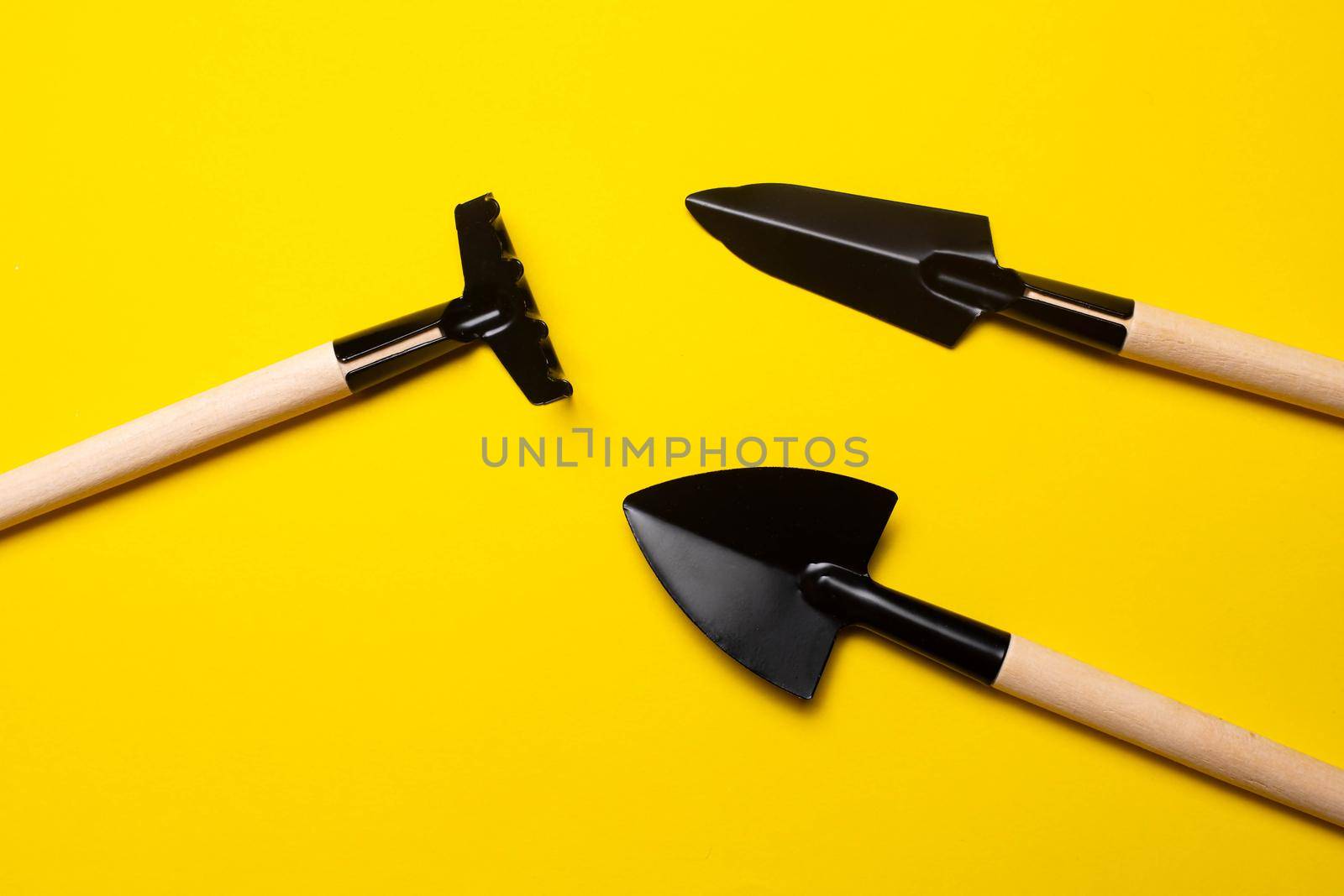 Garden shovels on a yellow background . Gardening layout. Spring planting. The care of plants. Work in the ground. yellow background. Copy space.