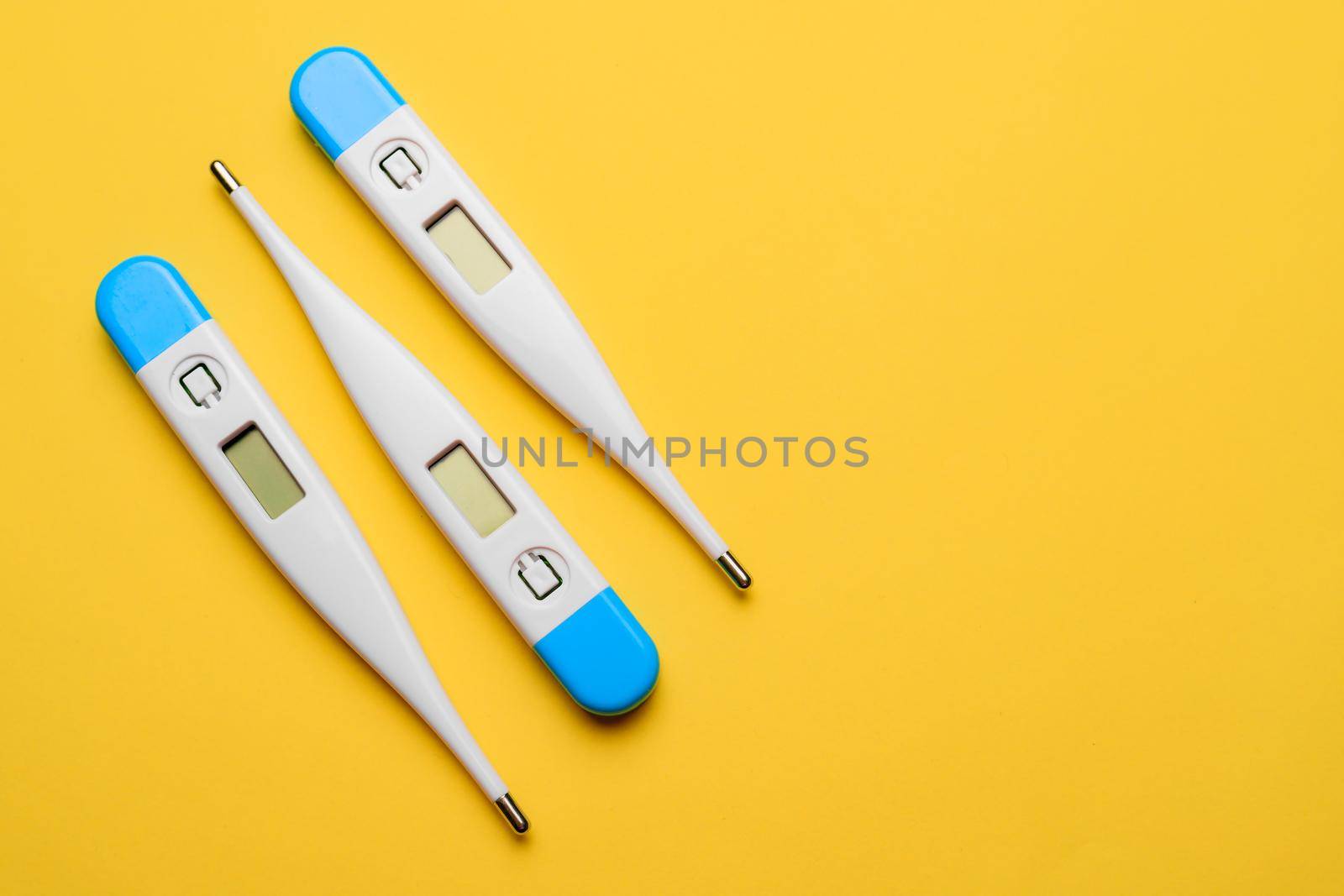 Electronic thermometers . Electronic thermometer on a yellow background. Temperature measurement. Safe thermometer. Modern medical equipment. Science and medicine. Article about safe thermometers. Technologies. Yellow background . Copy space