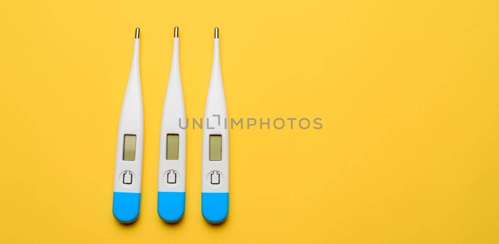 Electronic thermometers . Electronic thermometer on a yellow background. Temperature measurement. Safe thermometer. Modern medical equipment. Science and medicine. Article about safe thermometers. Technologies. Yellow background . Copy space