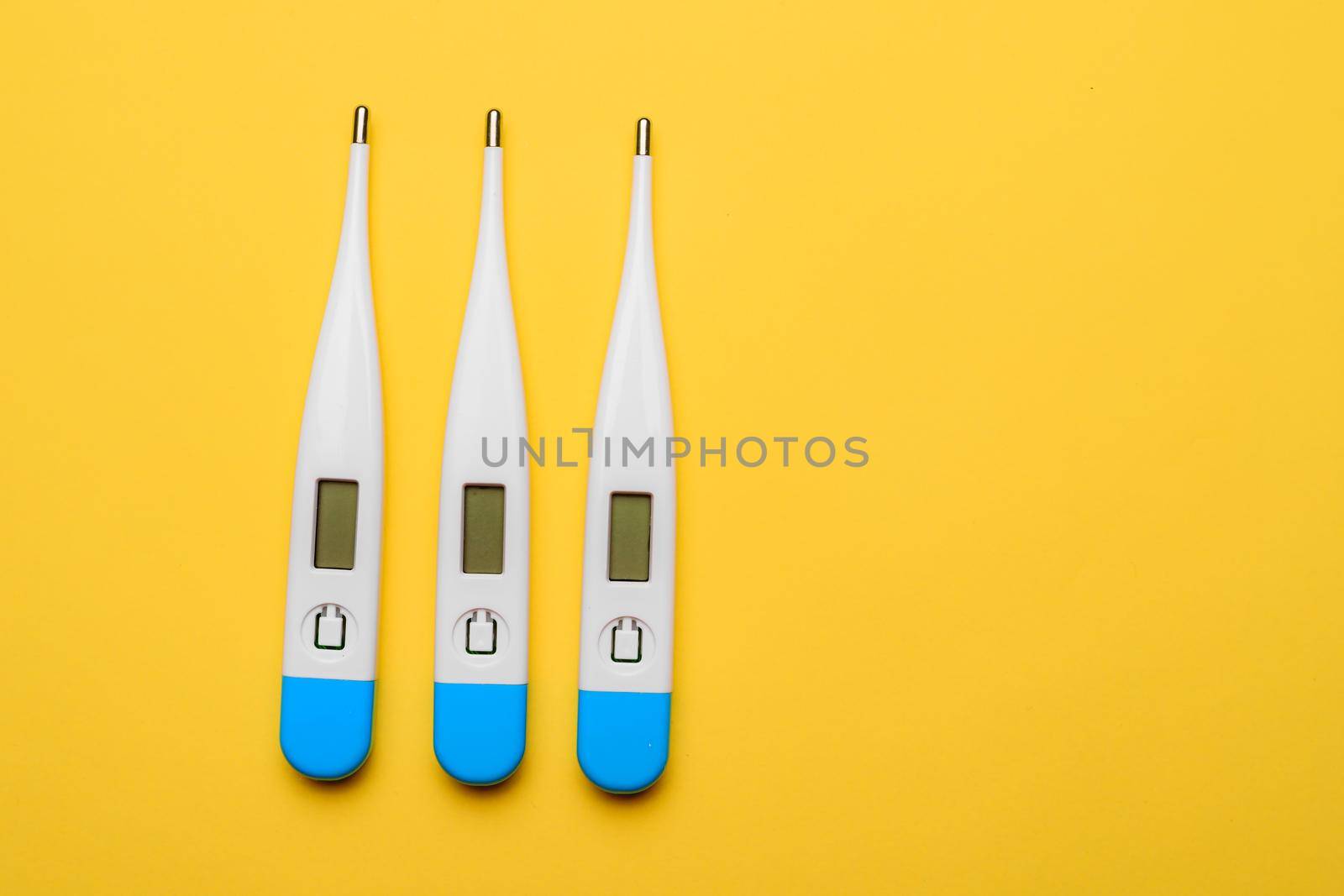 Electronic thermometers . Electronic thermometer on a yellow background. Temperature measurement. Safe thermometer. Modern medical equipment. Science and medicine. Article about safe thermometers. Technologies. Yellow background . Copy space