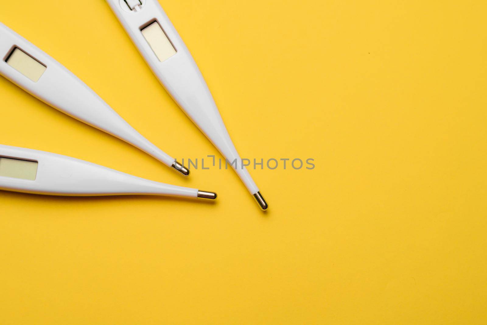 Electronic thermometers . Electronic thermometer on a yellow background. Temperature measurement. Safe thermometer. Modern medical equipment. Science and medicine. Article about safe thermometers. Technologies. Yellow background . Copy space
