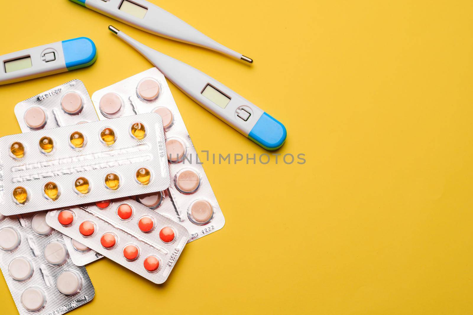 A pile of pills on a yellow background . Treatment and prevention. Article about the purpose of treatment. A cure for the disease. Pills in a blister. Lots of medicine. Yellow background. Copy space