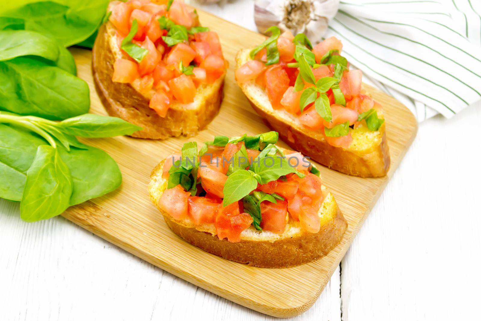 Bruschetta with tomato and spinach on white wooden table by rezkrr