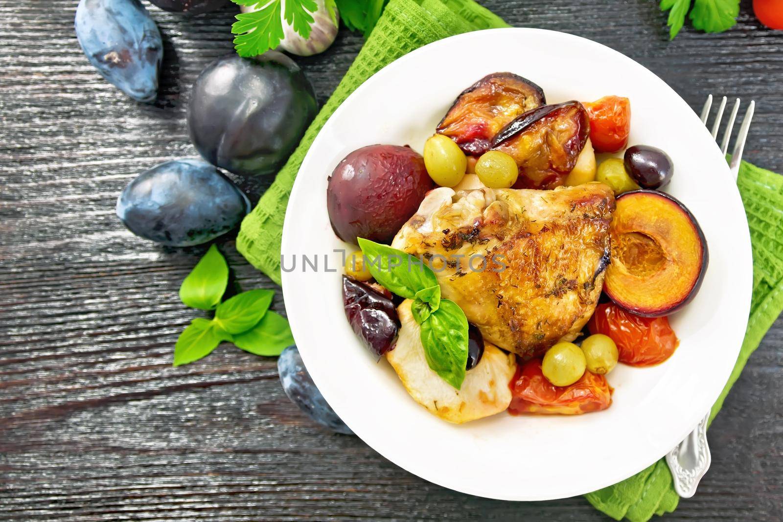 Chicken with fruits and tomatoes in plate on board top by rezkrr