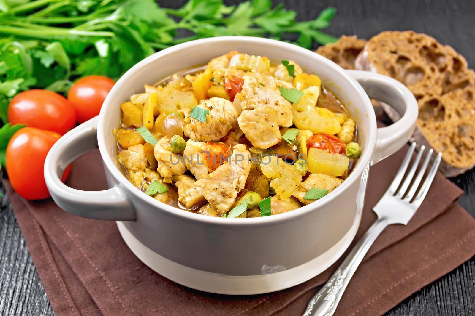 Chicken with vegetables and peas in saucepan on table by rezkrr