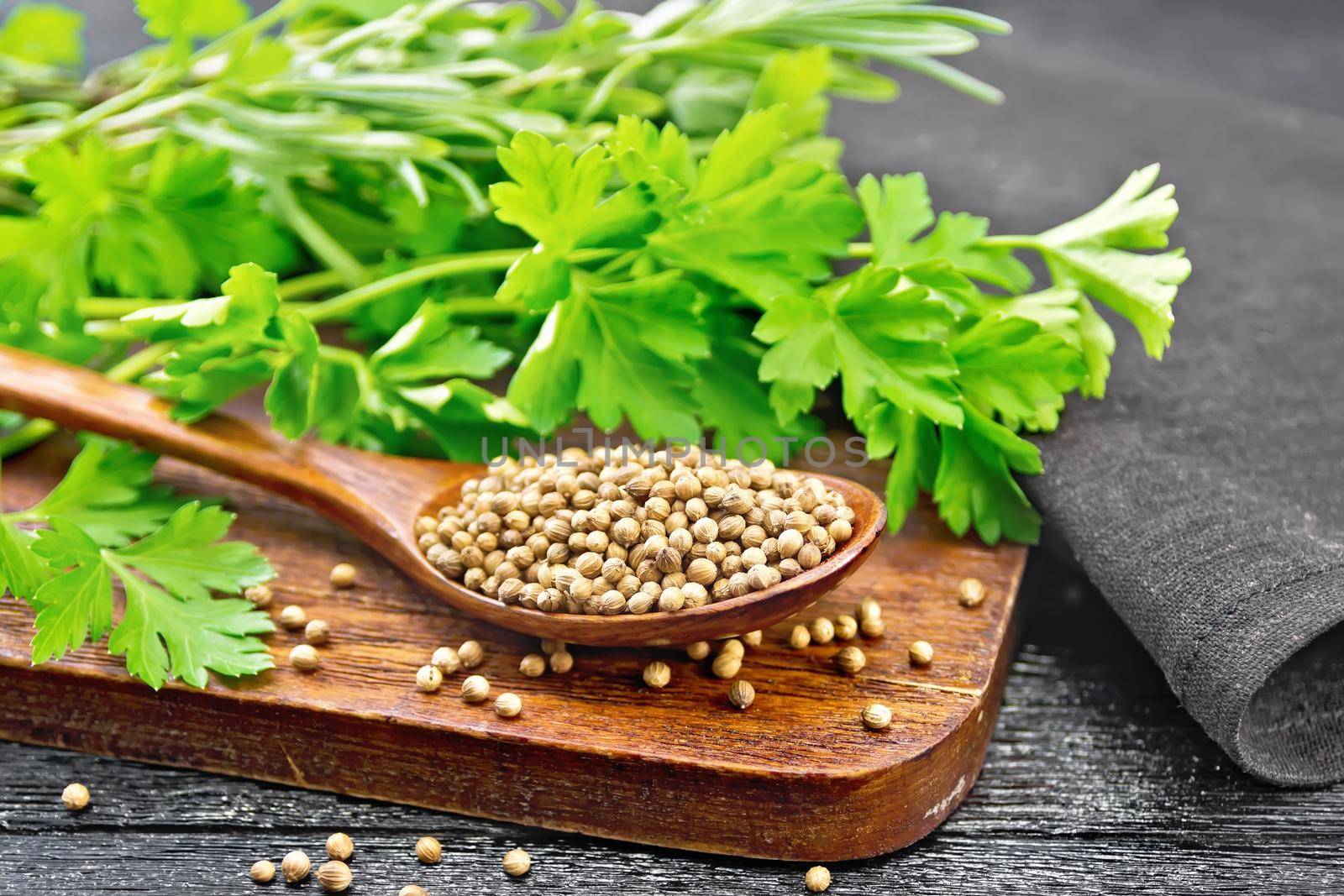 Coriander seeds in spoon on black board by rezkrr