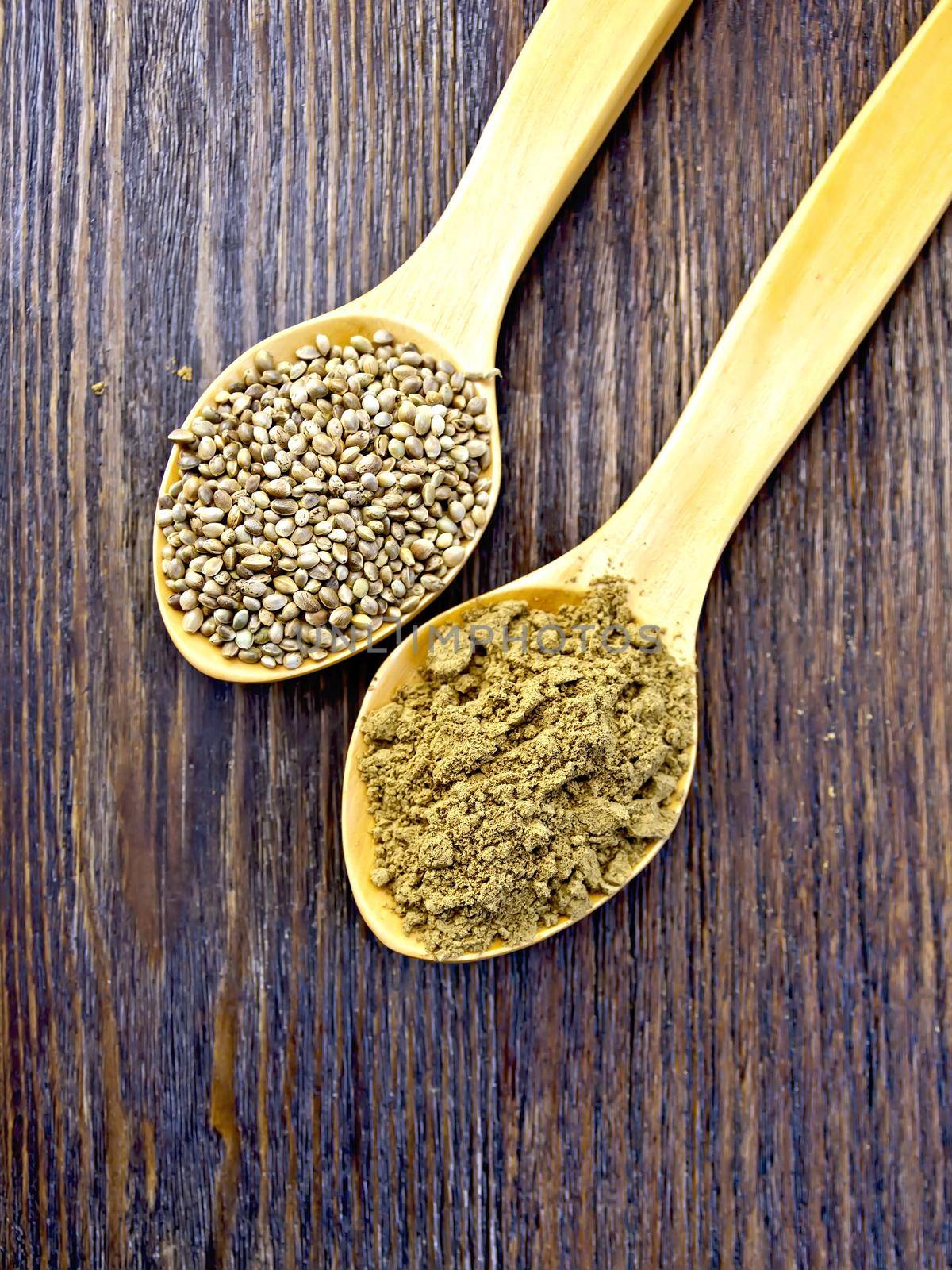 Flour and hemp seed in a wooden spoon on a background of the wooden planks on top