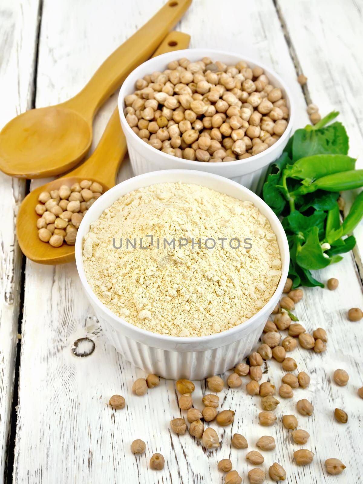 Flour chickpeas in white bowl with peas on board by rezkrr