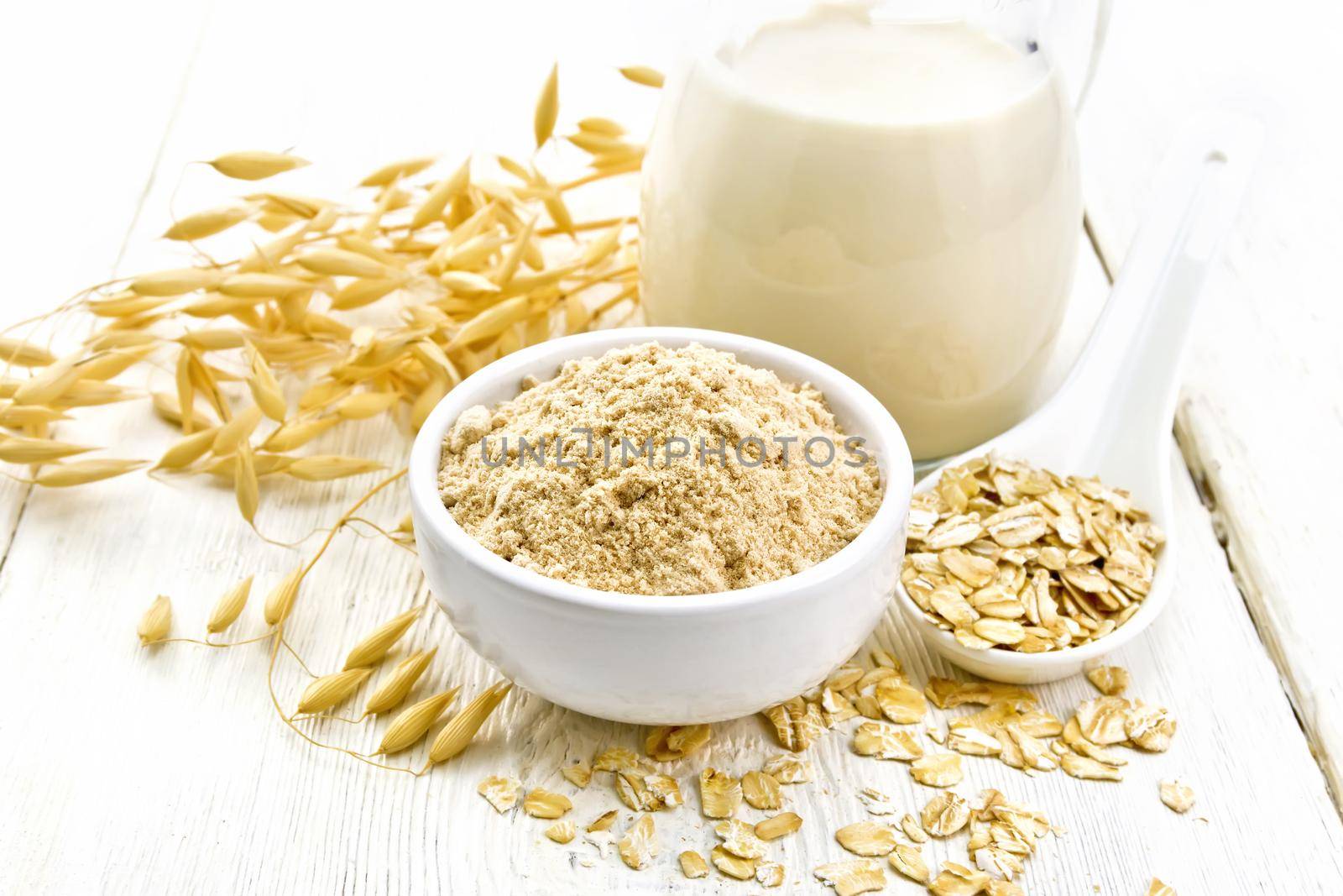 Flour oat in bowl with milk on white board by rezkrr