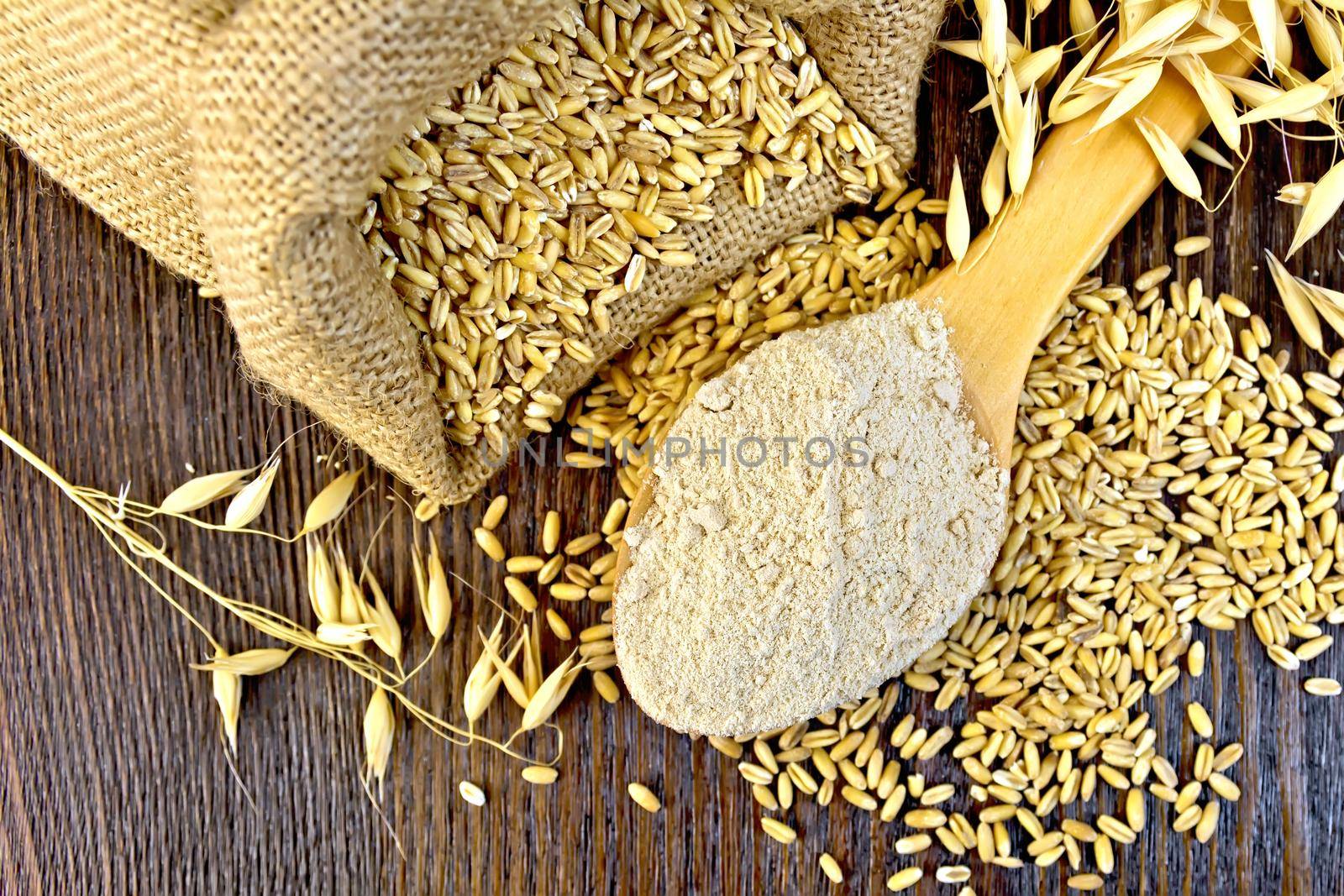 Flour oat in spoon with grain on board top by rezkrr