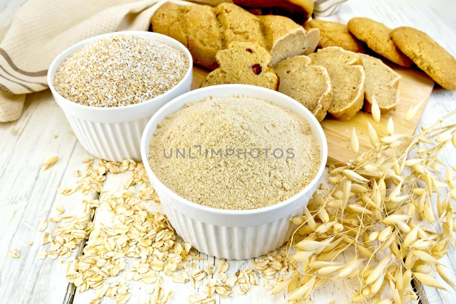 Flour oat in white bowl with bread on board by rezkrr