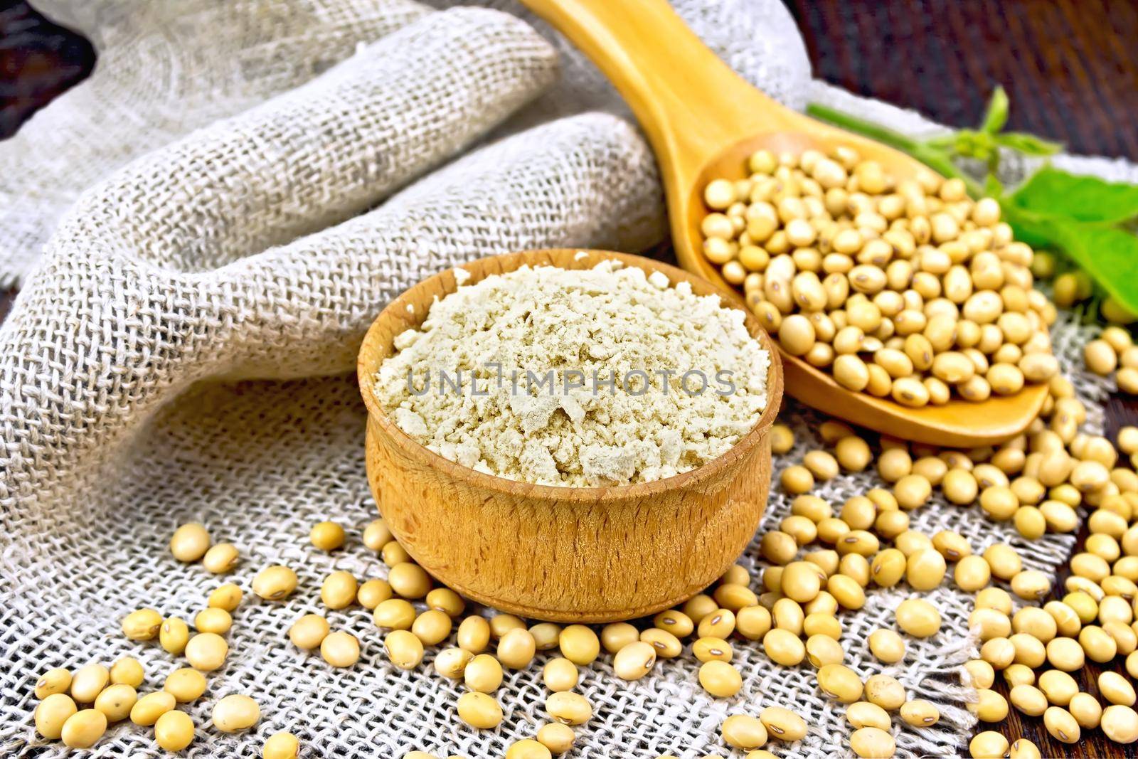 Flour soy in bowl with soybeans on board by rezkrr