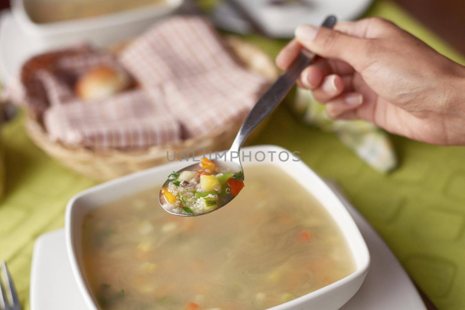 Young woman eating hot and healthy soup.