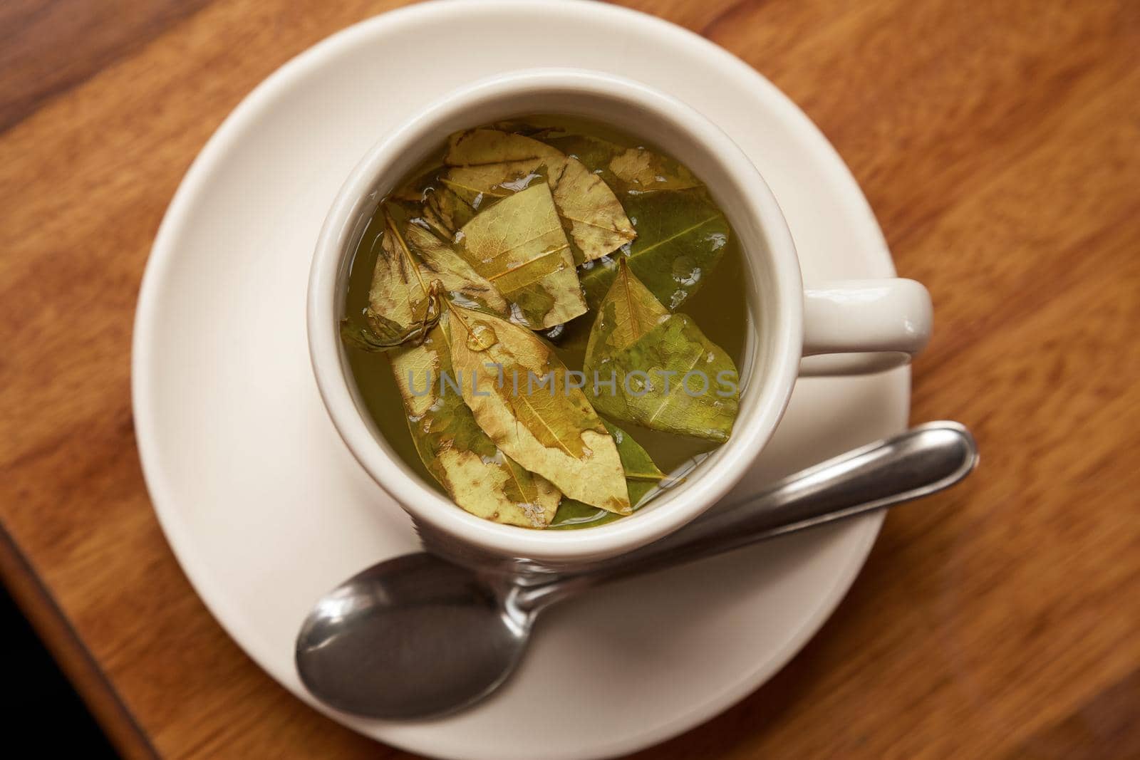 Cup of Coca Tea on Wooden table. Traditional refreshment for people in South America, especially in Peru and Bolivia.