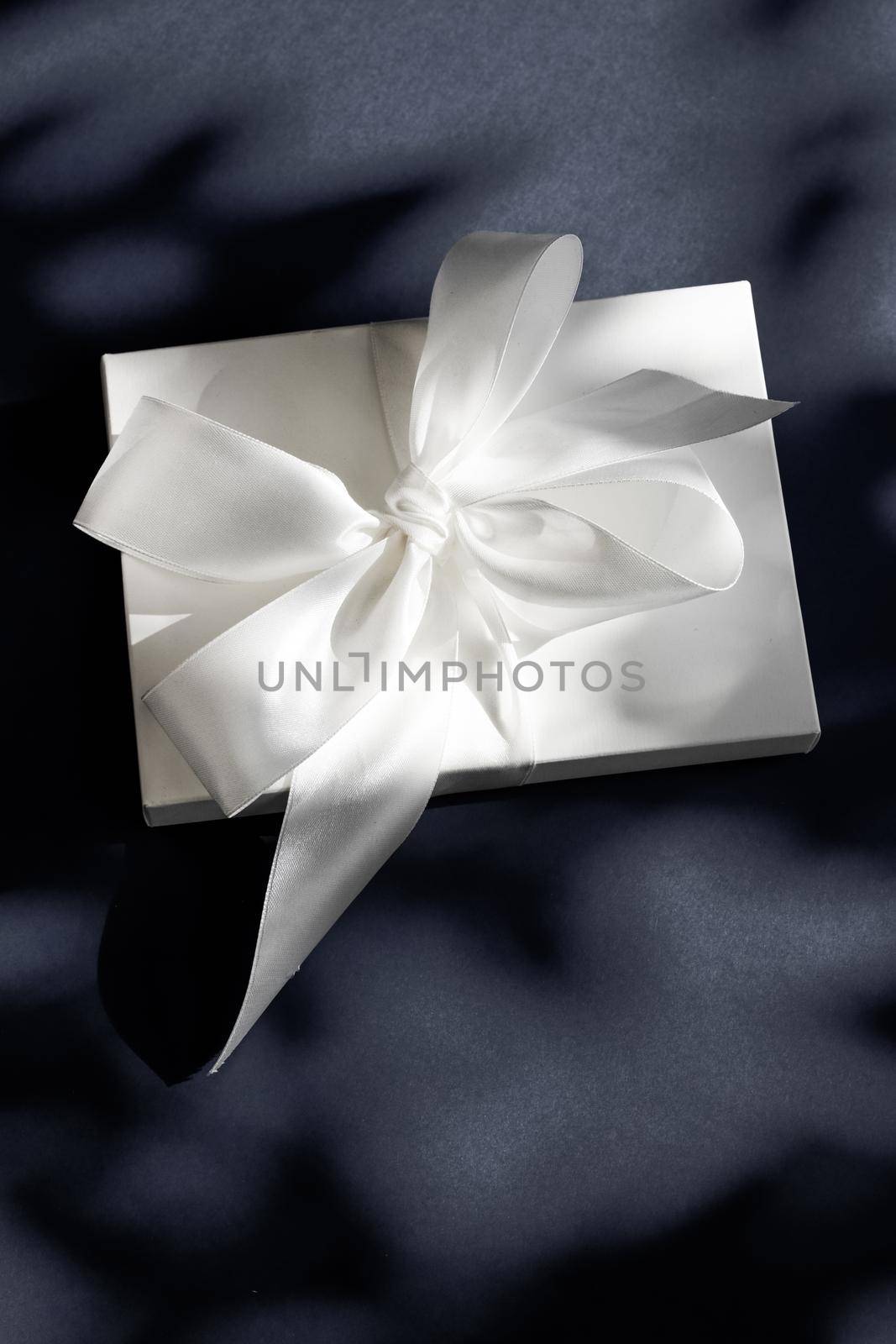 Anniversary celebration, shop sale promotion and luxe surprise concept - Luxury holiday white gift box with silk ribbon and bow on black background, luxe wedding or birthday present