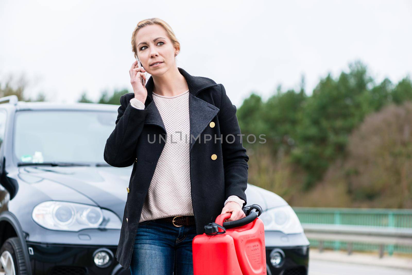 Woman out of gas with her car phoning for somebody to pick her up by Kzenon