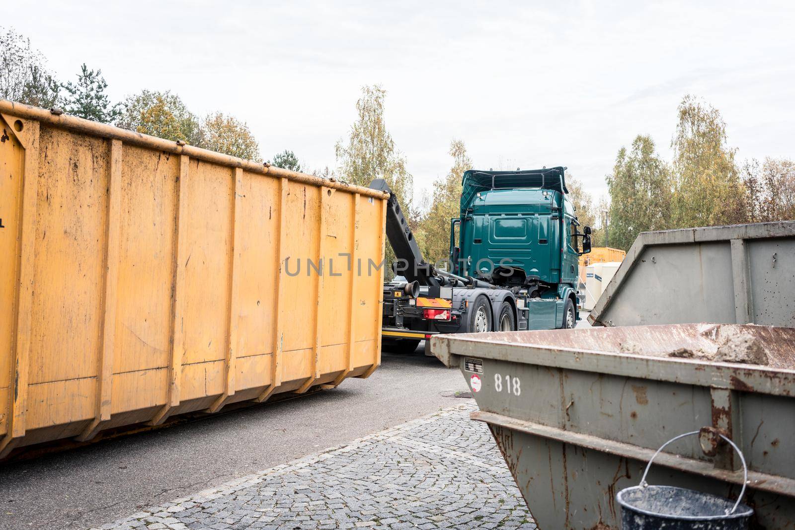 Truck loading container with waste on recycling center by Kzenon