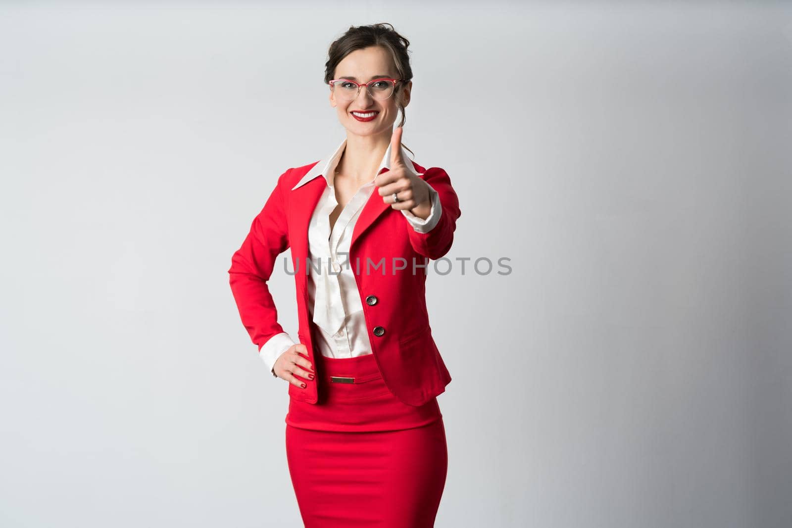 Businesswoman showing thumbs up by Kzenon