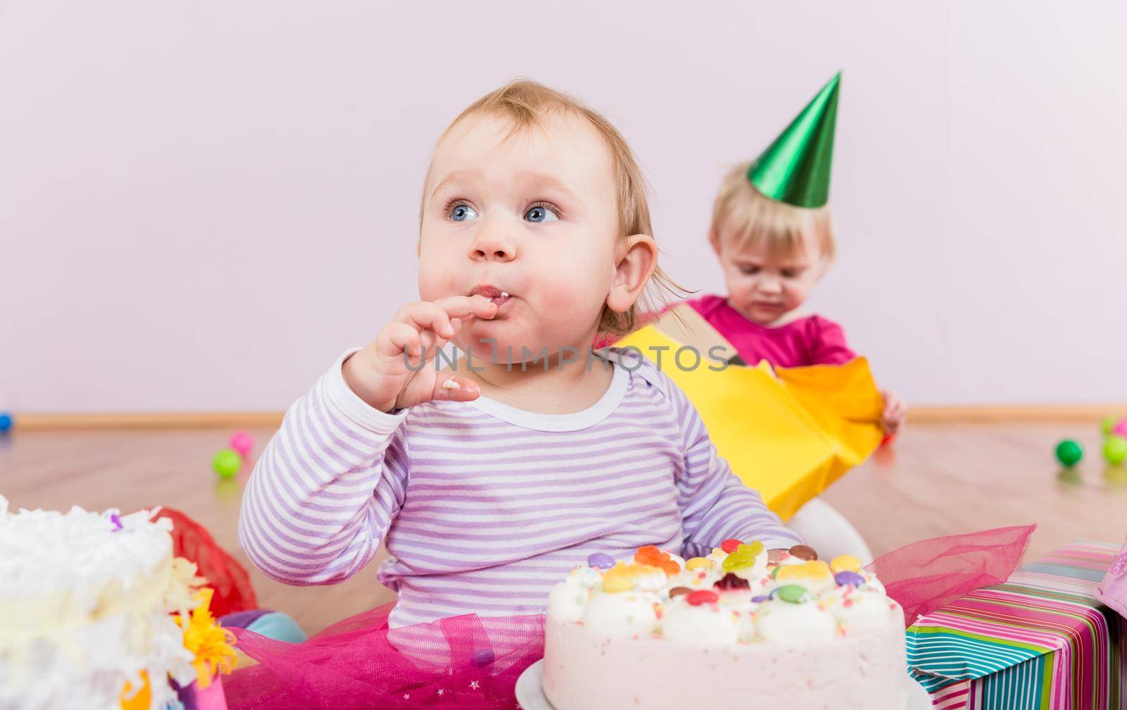 Toddler eating birthday cake in kindergarten