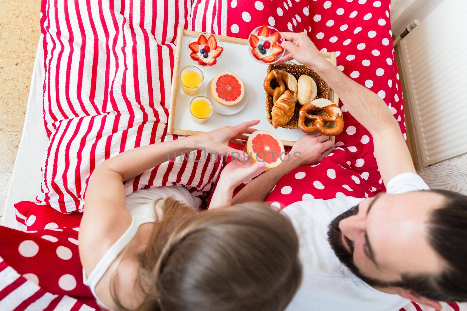 Young couple in love having breakfast in bed