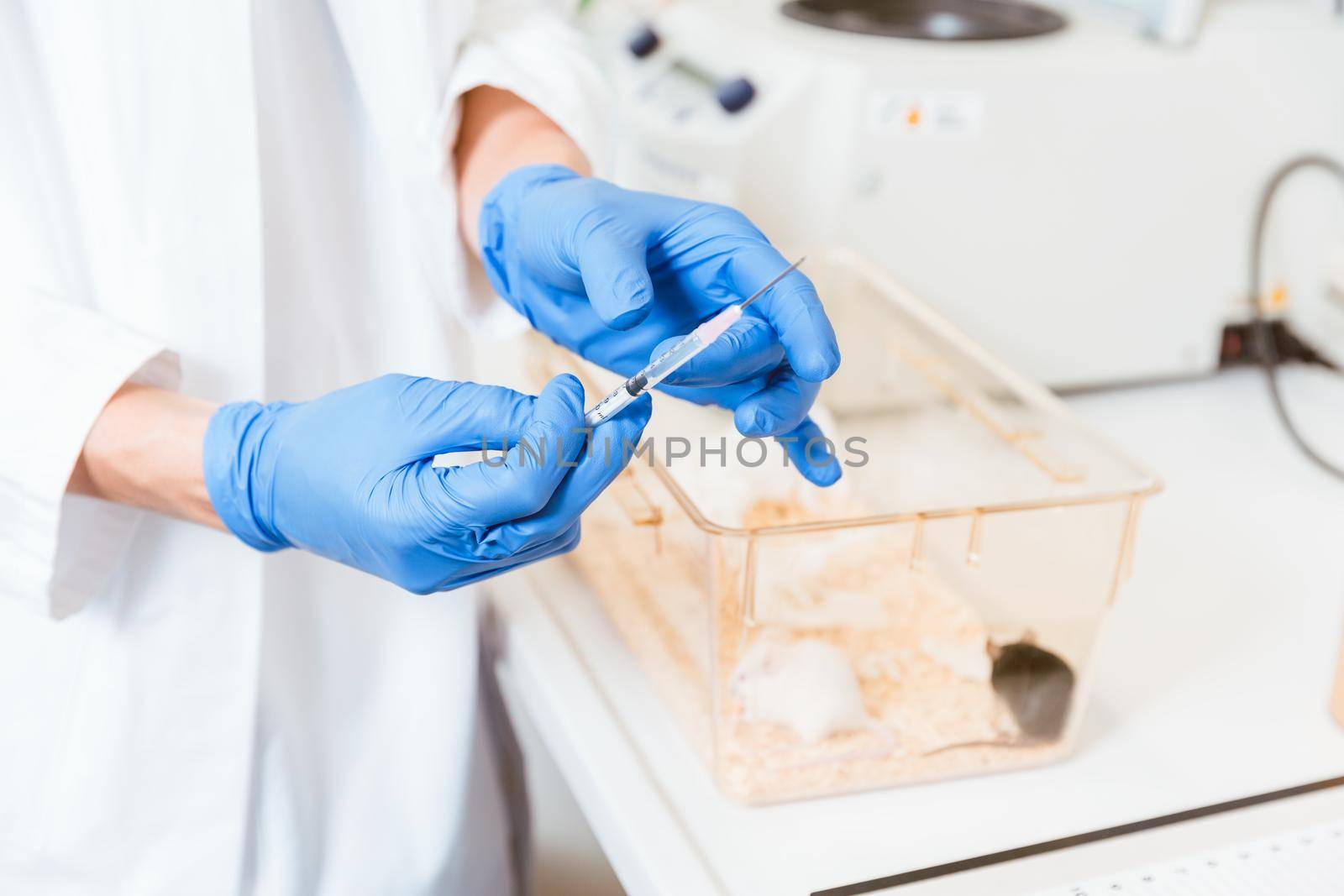 Female scientist hand using syringe by Kzenon