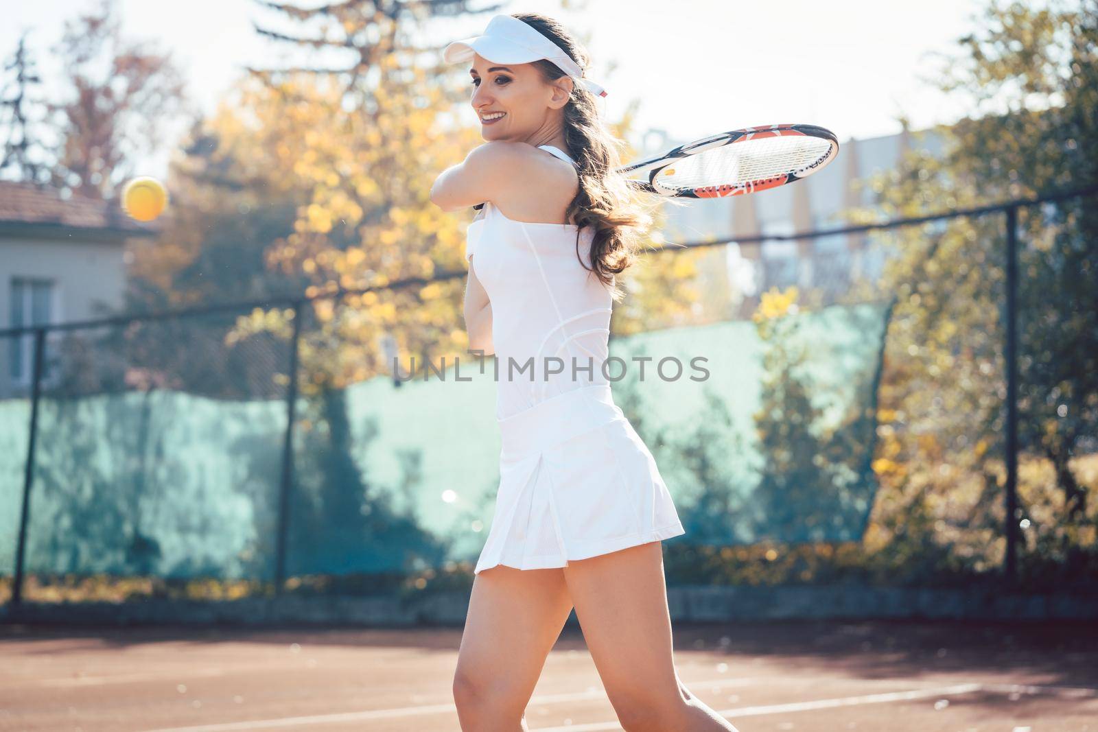 Woman playing tennis on court by Kzenon