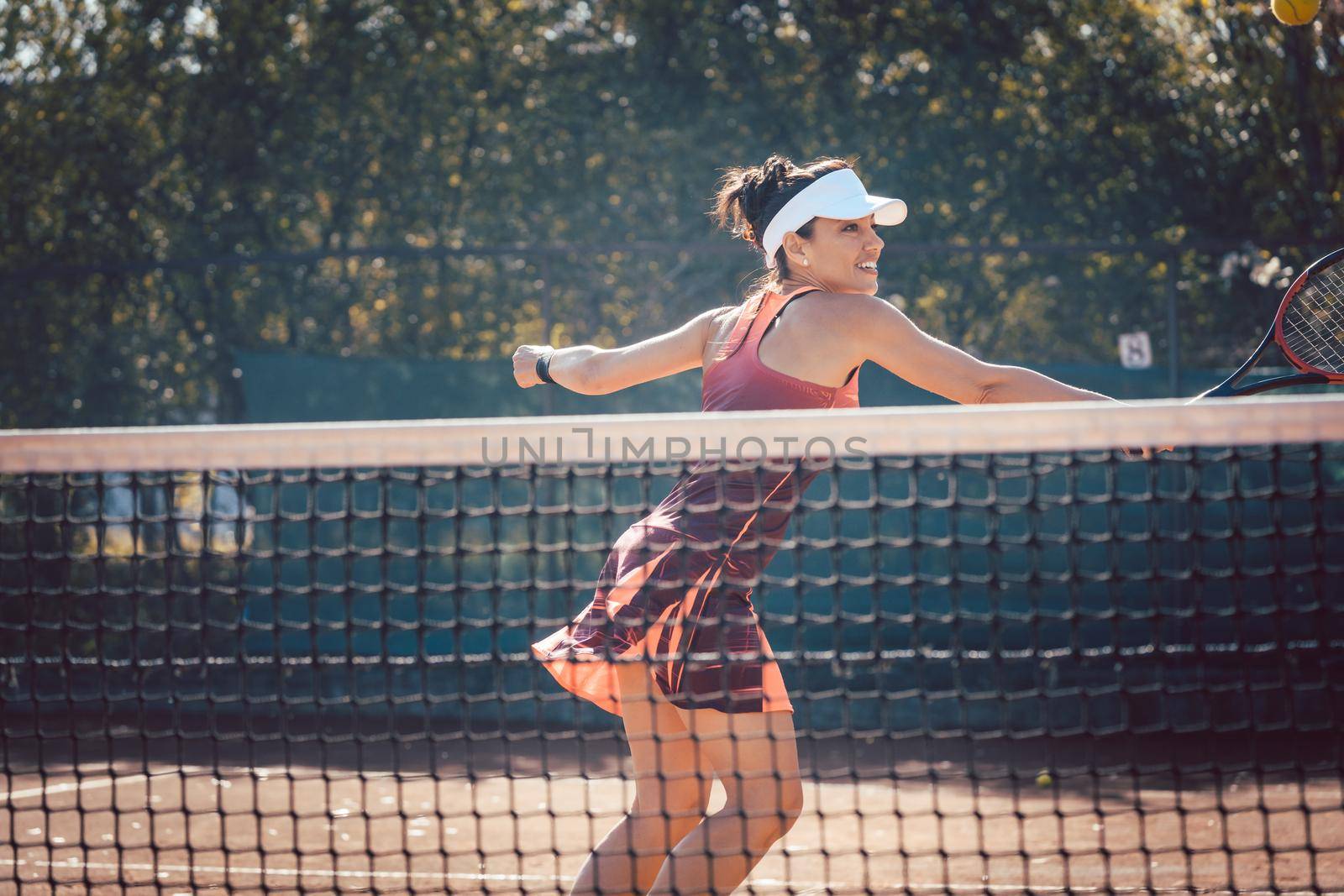 Woman in red sport dress playing tennis by Kzenon