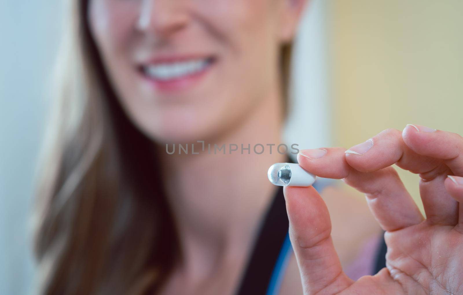 Patient in hospital holding video pill for capsule endoscopy into camera