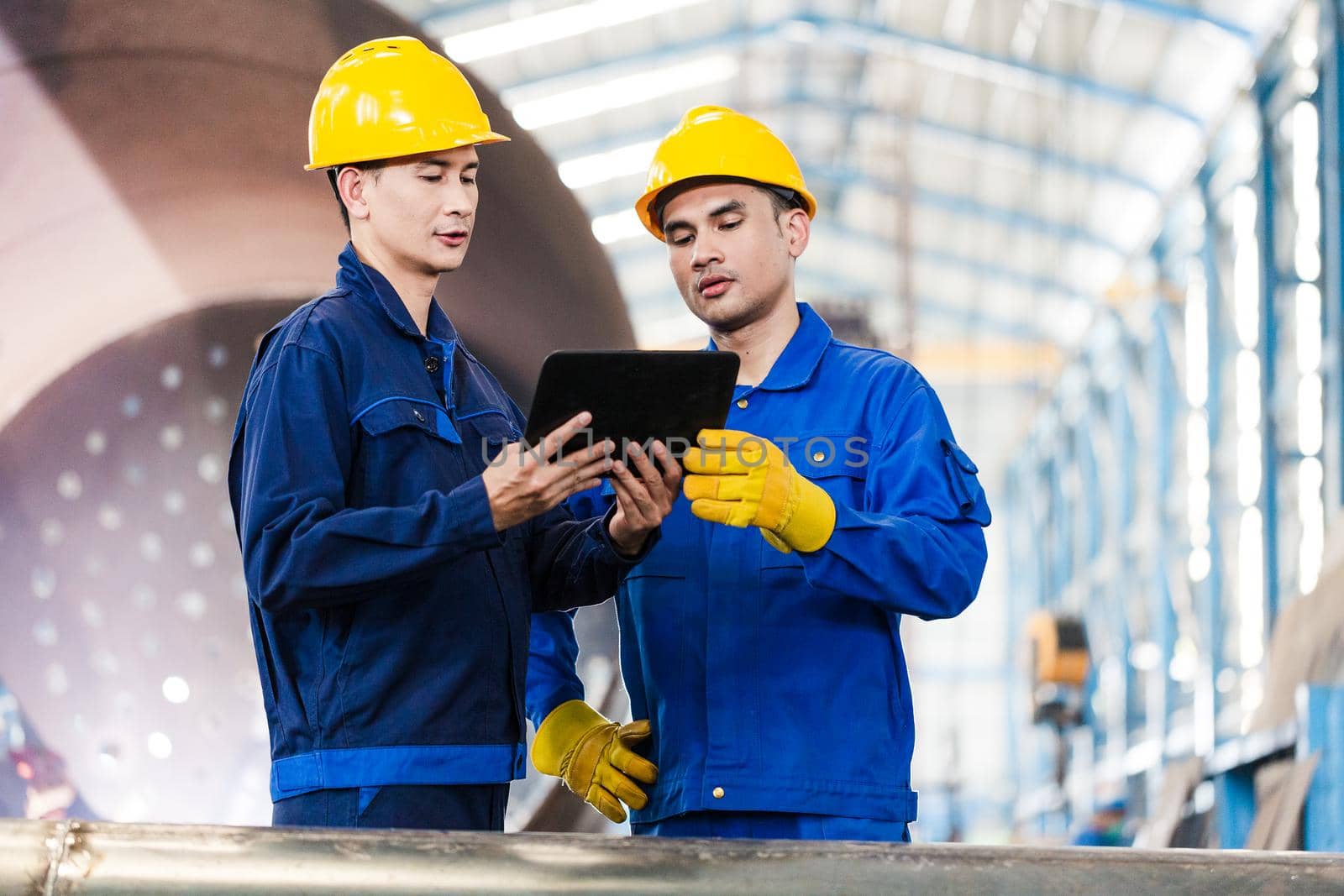 Experts checking information on tablet PC in a modern factory by Kzenon