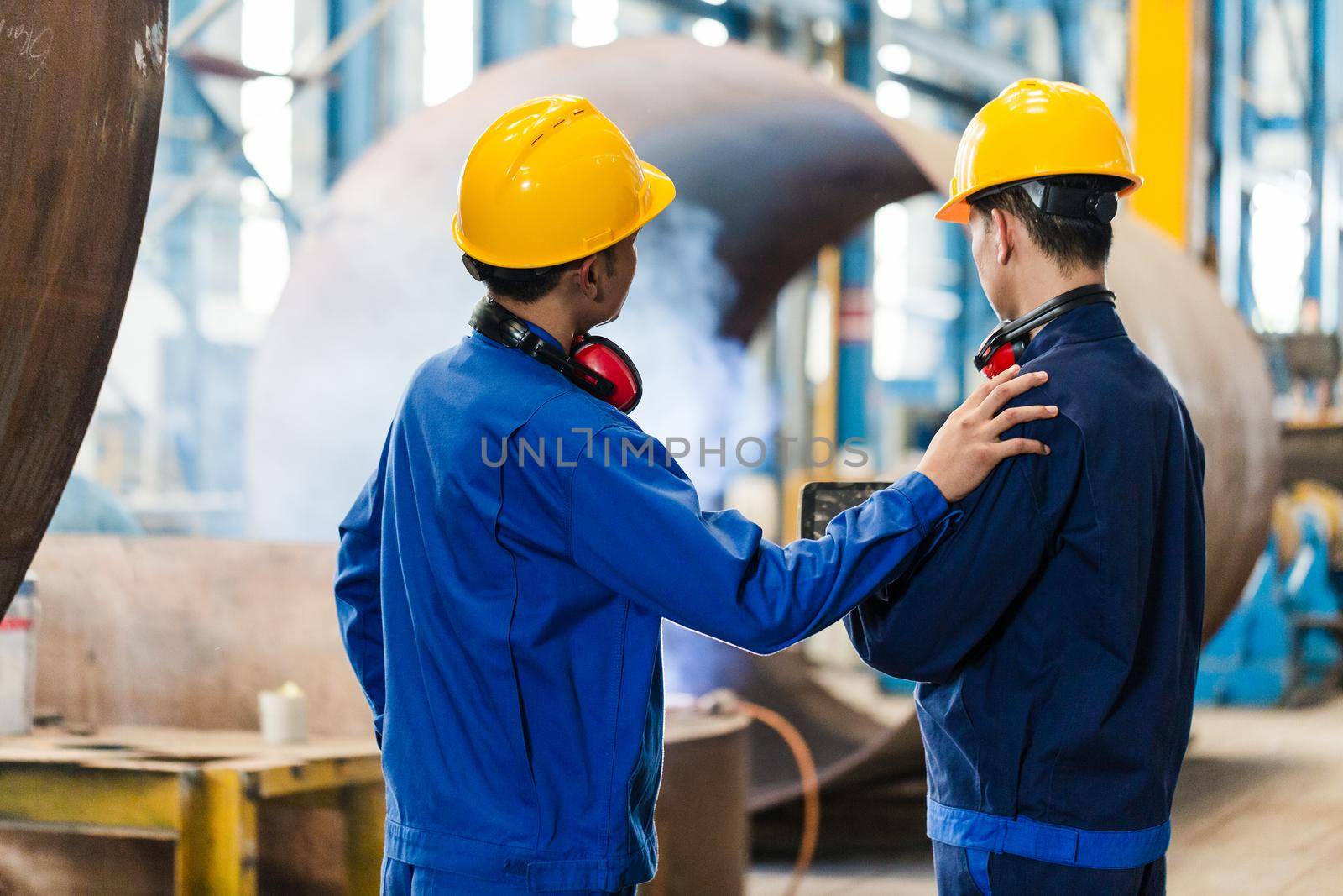 Asian expert checking the quality requirements of manufactured industrial steam boilers