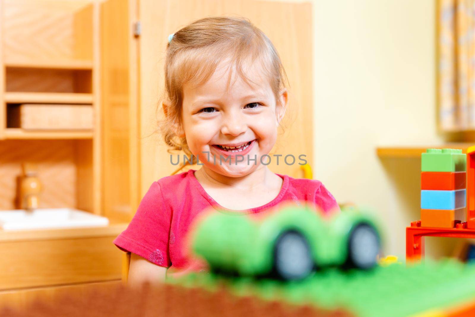 Little girl playing with a toy car by Kzenon