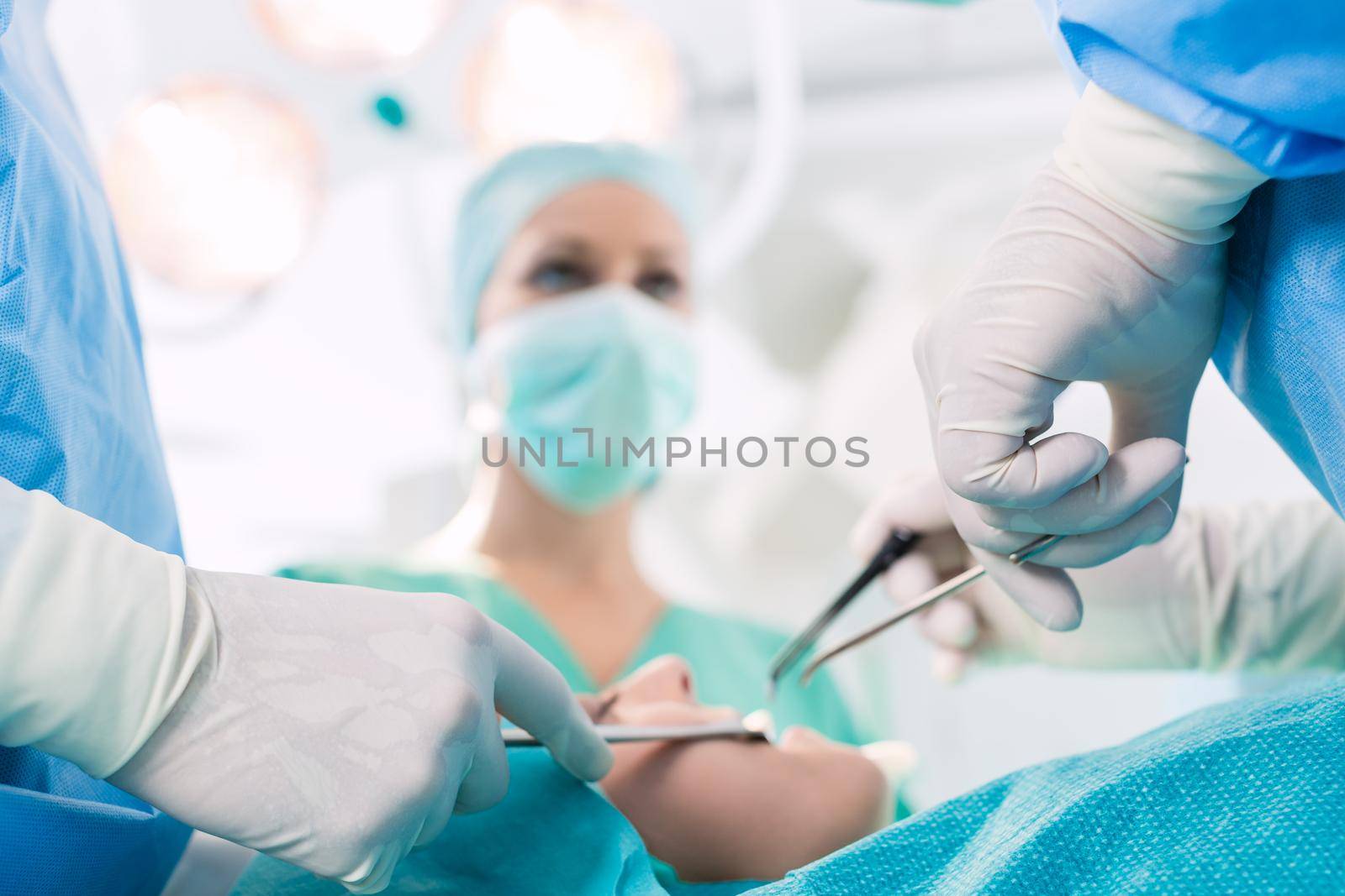 Surgeons operating patient in operation theater at hospital